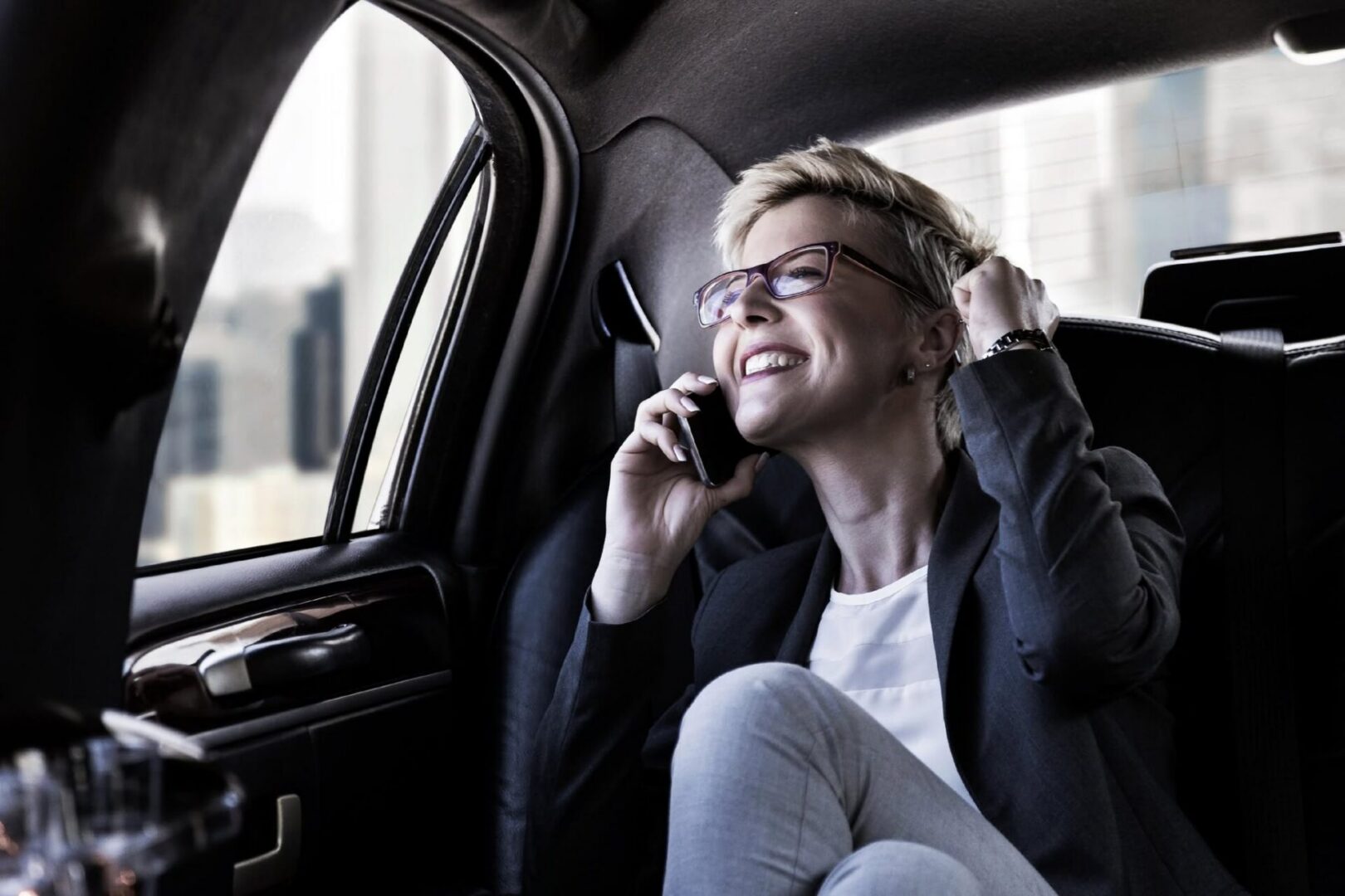 Businesswoman smiling while on phone in car